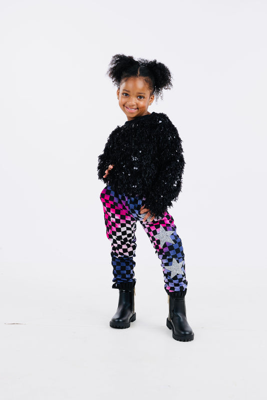 Trendy girls' checker joggers with a bold pink and purple tie-dye pattern, featuring a stylish checkerboard print and silver stars for added sparkle. Made from soft, stretchy fabric for comfort and versatility, with an elastic waistband for a secure fit. Perfect for casual wear or active days