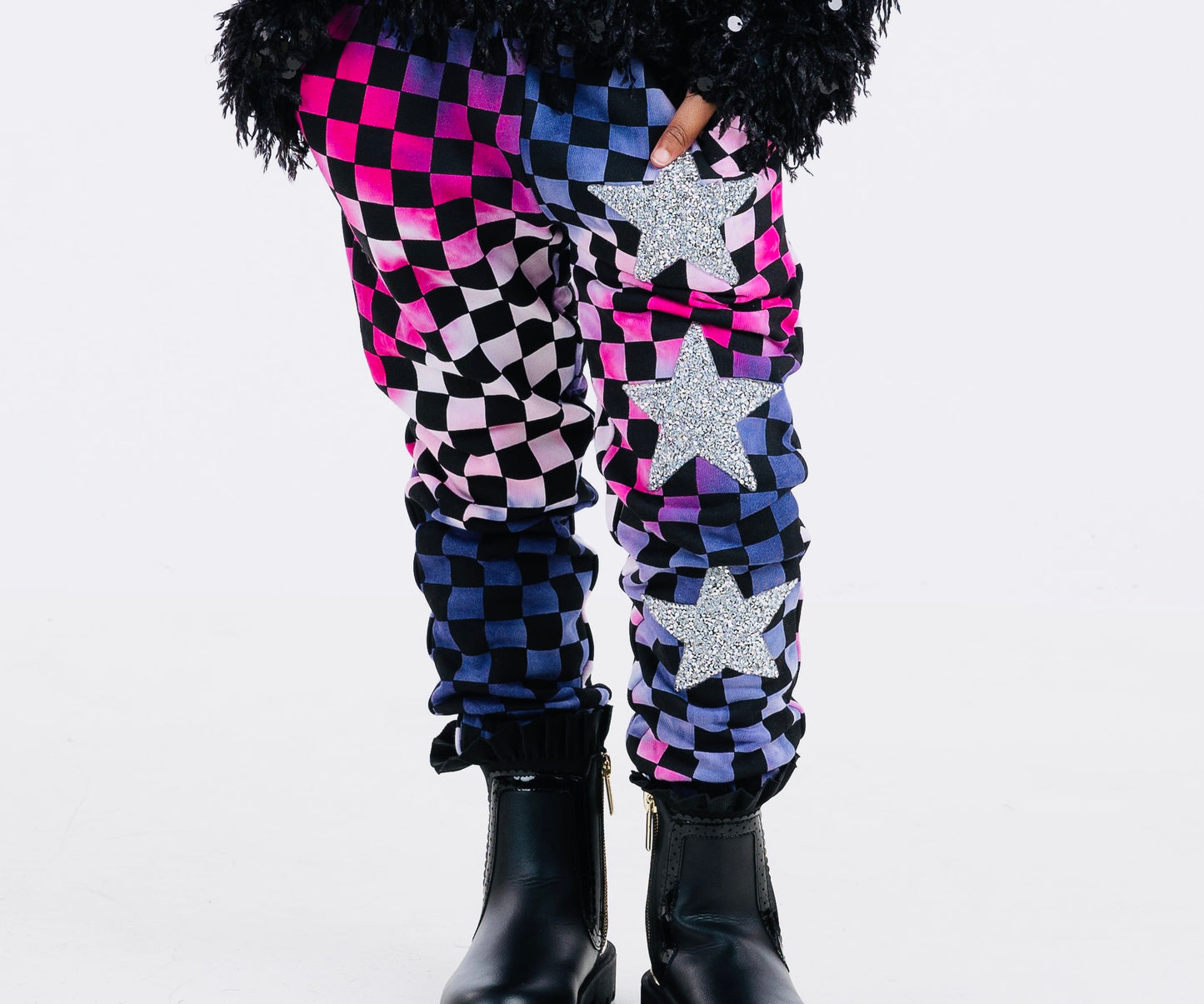 Trendy girls' checker joggers with a bold pink and purple tie-dye pattern, featuring a stylish checkerboard print and silver stars for added sparkle. Made from soft, stretchy fabric for comfort and versatility, with an elastic waistband for a secure fit. Perfect for casual wear or active days